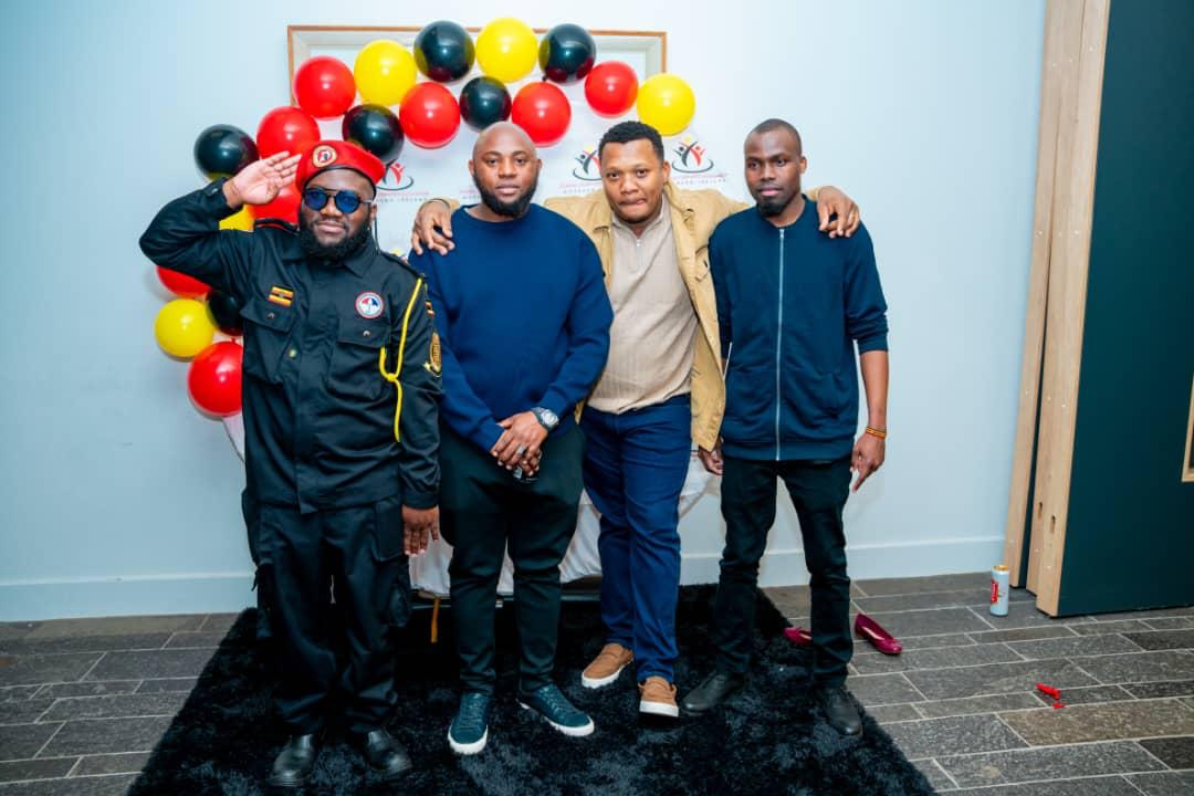 Members posing together beneath Uganda-coloured balloons